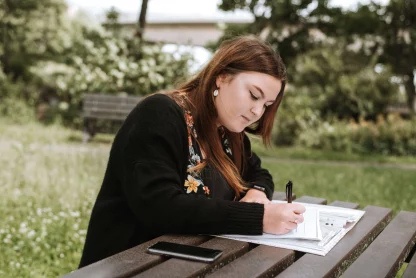 A young lady is journaling her emotions in calm and serene nature