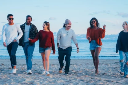 a group of friends walking on a beach