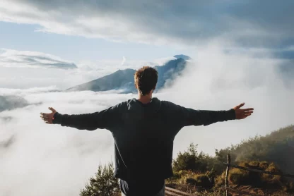 a man is standing on top of a mountain and experiencing the beautiful scenery