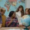 a teacher is showing globe to children