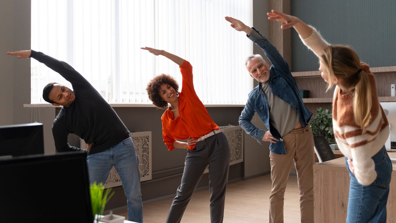 Colleagues at the office stretching during a work day